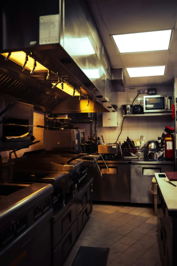 Commercial restaurant kitchen with stainless steel prep stations and ranges